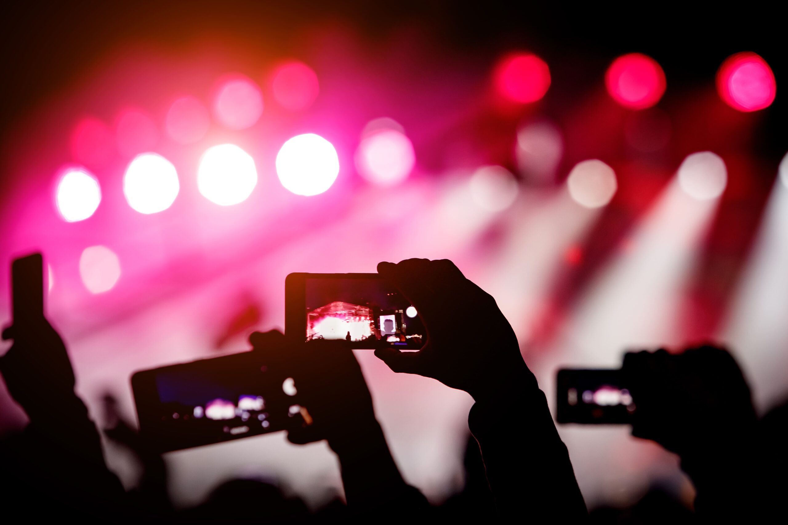 silhouette-hands-using-smartphones-take-pictures-videos-live-music-show